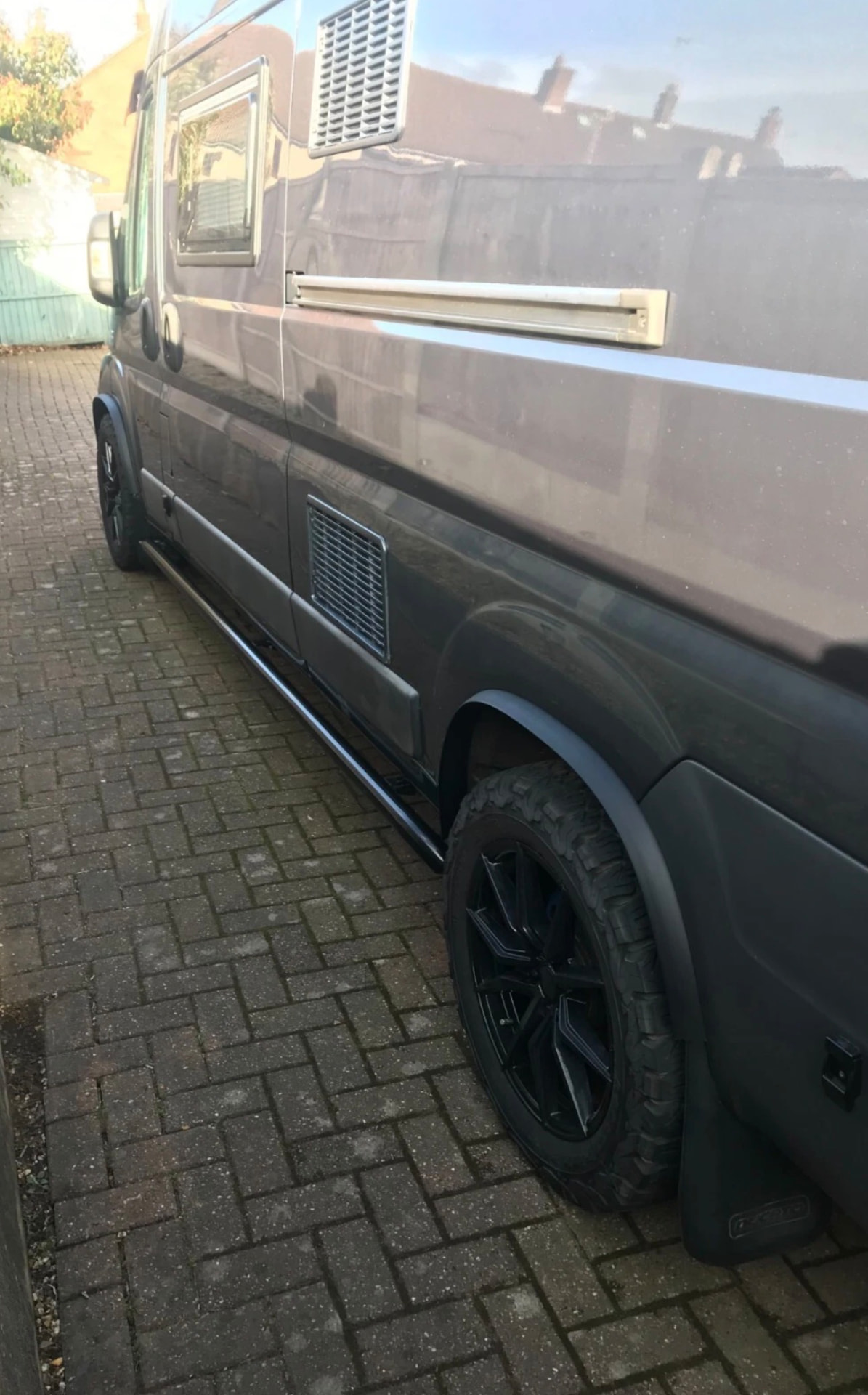 Van side profile showing extended arches, mudflaps and black side bars